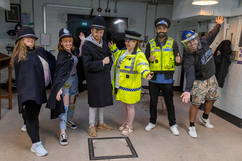 group of visitors evidently enjoying wearing elements of police uniform!